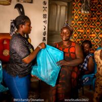 A volunteer is seen handing over a bad of items to a woman